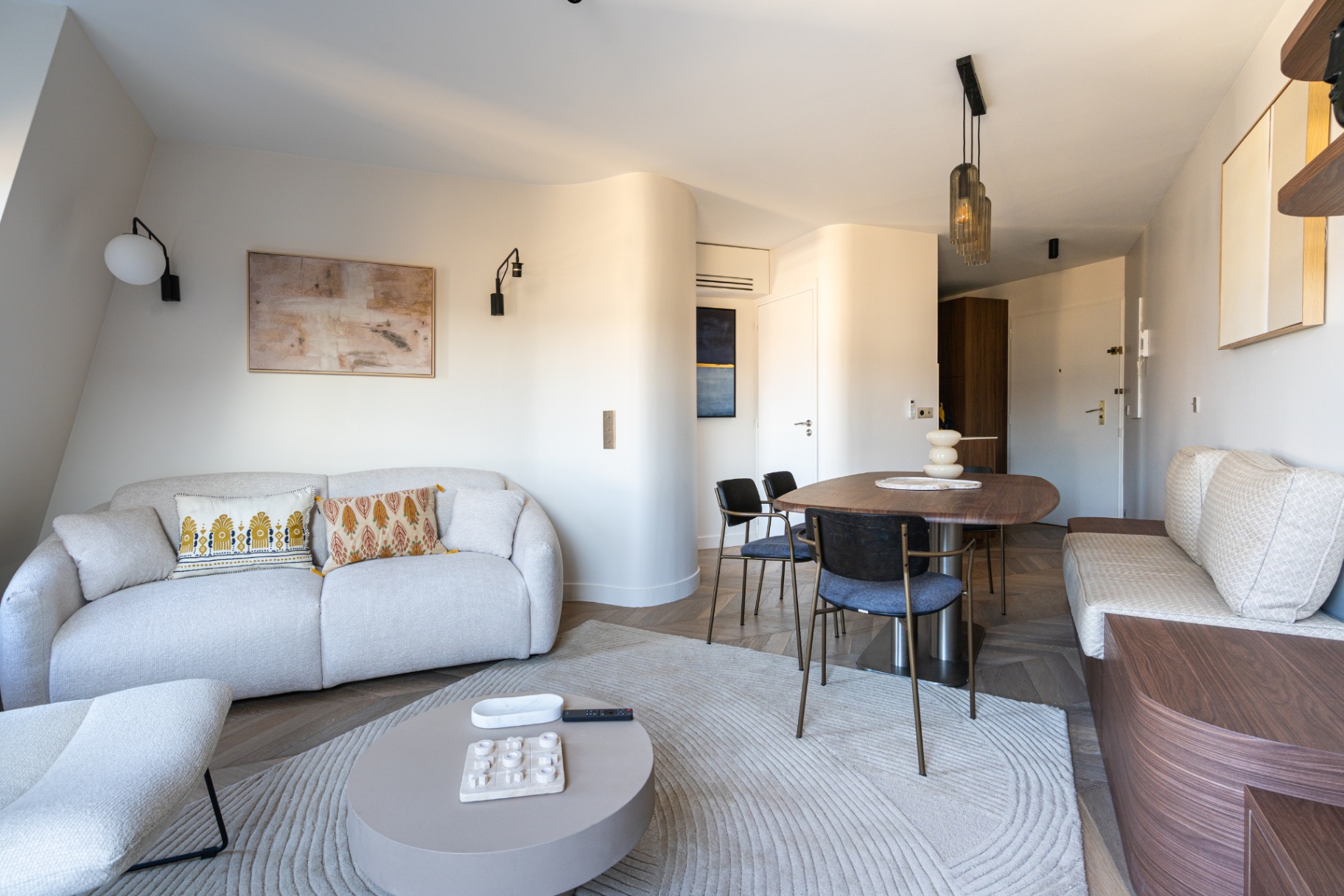 Salon élégant de l'appartement Wagram avec parquet chevron et vue sur les toits de Paris